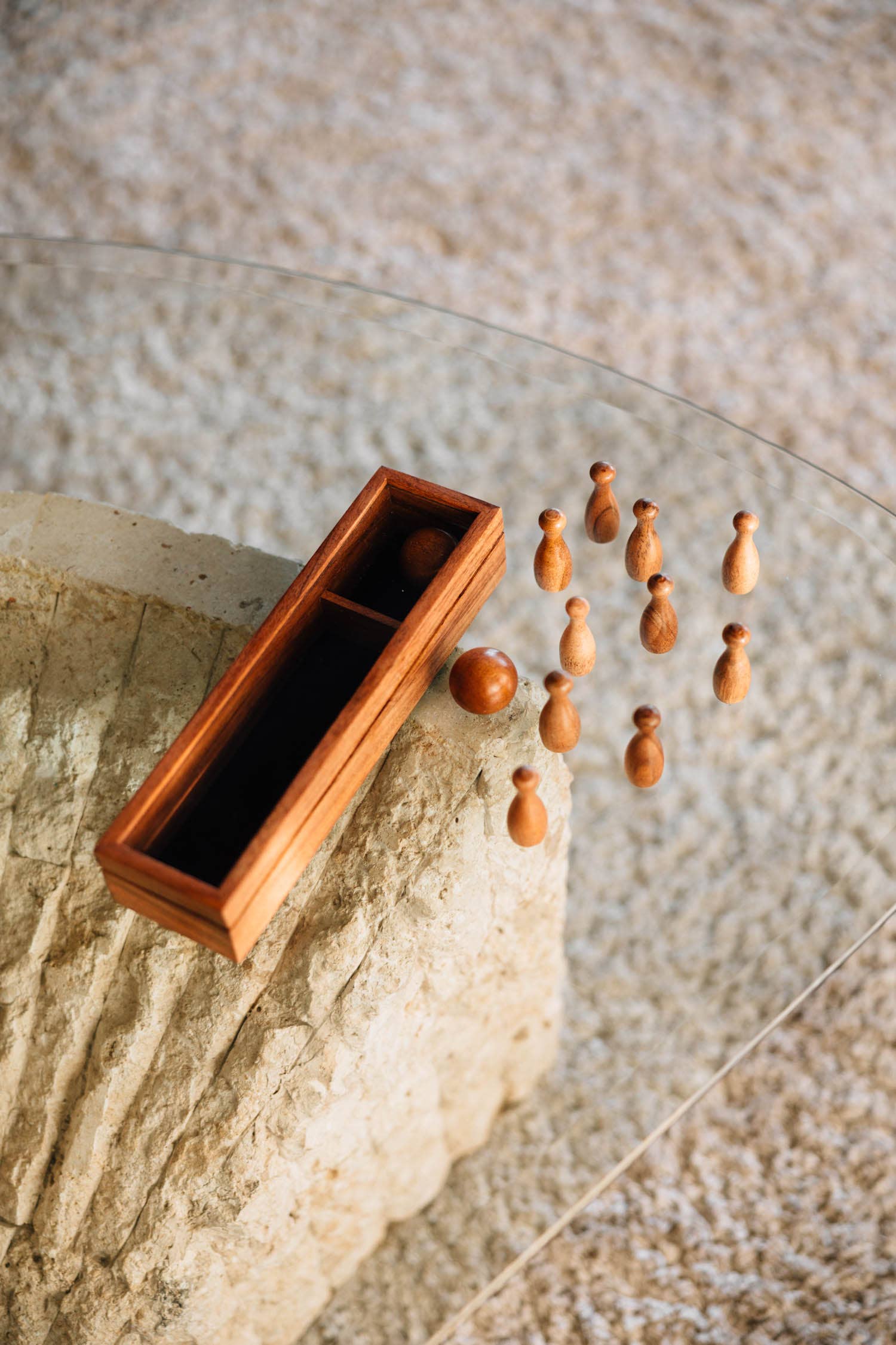 Wooden gaming pieces and box on a textured surface