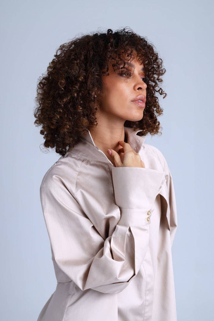 Woman wearing a light-colored shirt against a plain background