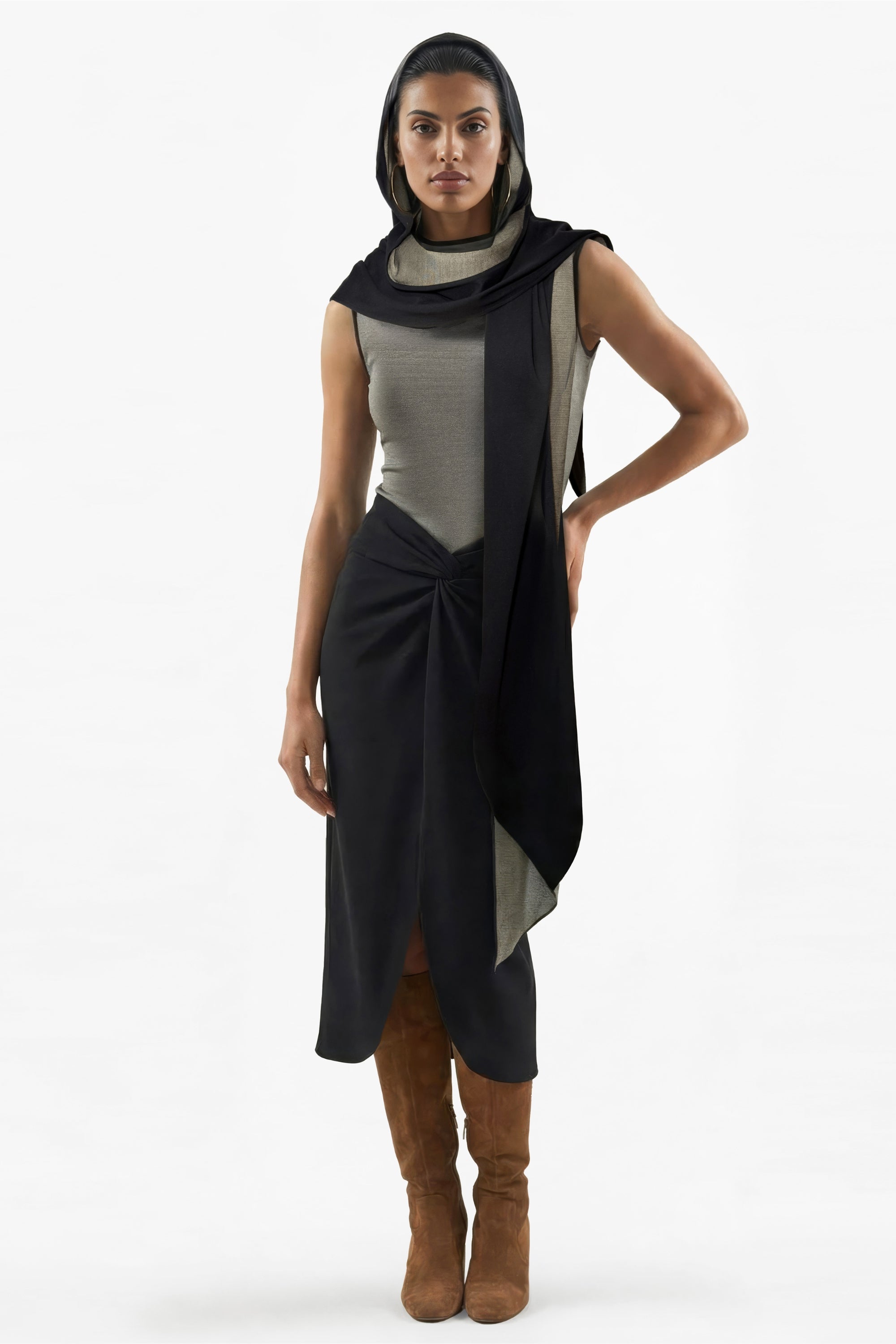 Woman wearing a black and gray dress with brown boots on a white background