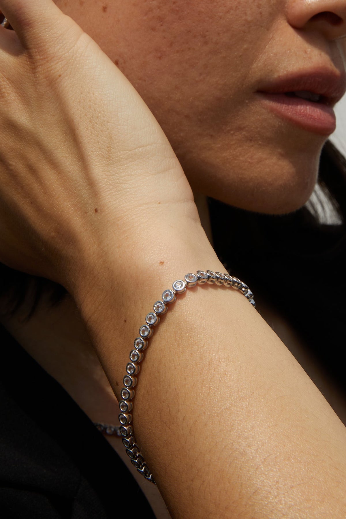 Close-up of a person wearing a silver bracelet on their wrist.