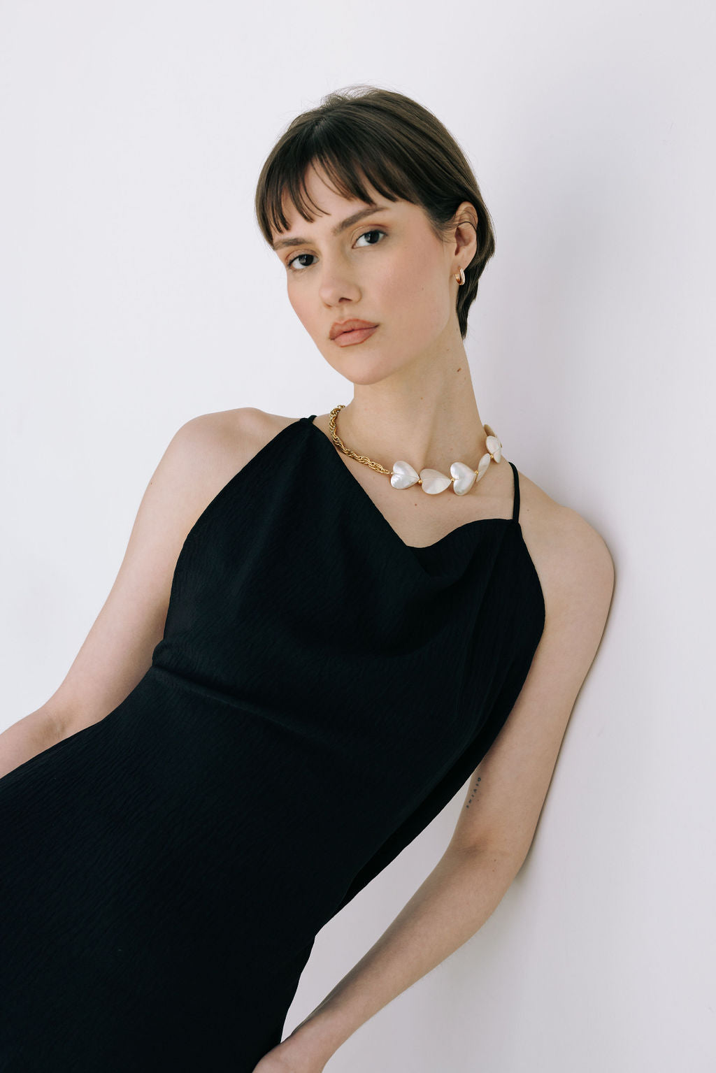 Woman wearing a black dress with a white background