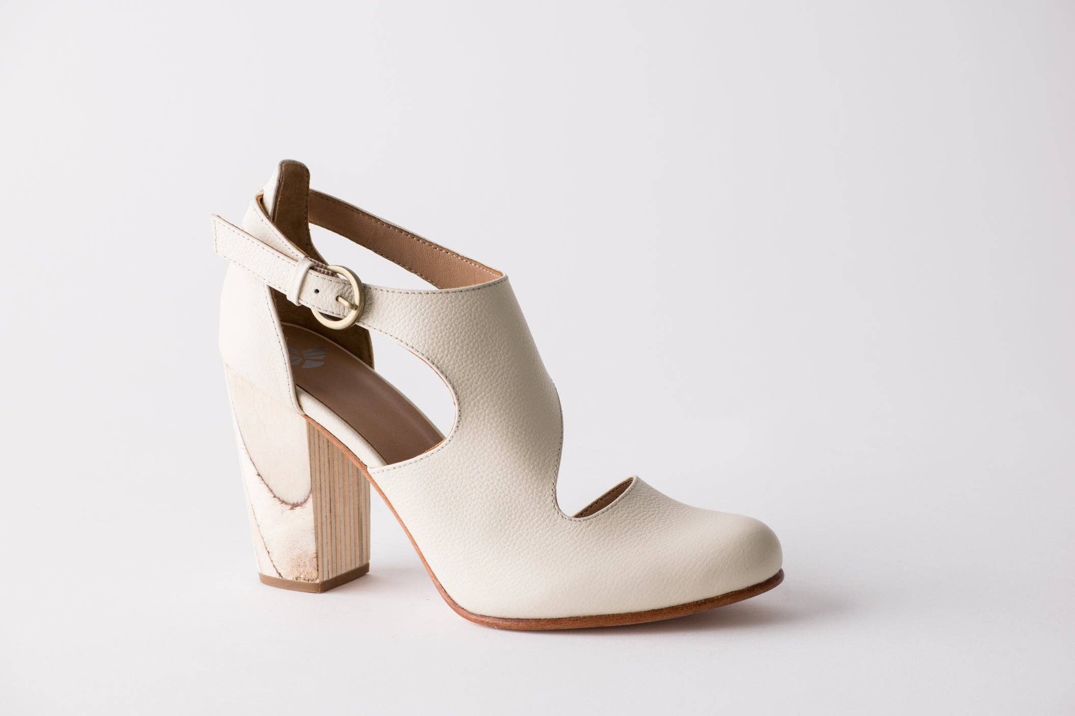White ankle boot with wooden block heel on a light gray background