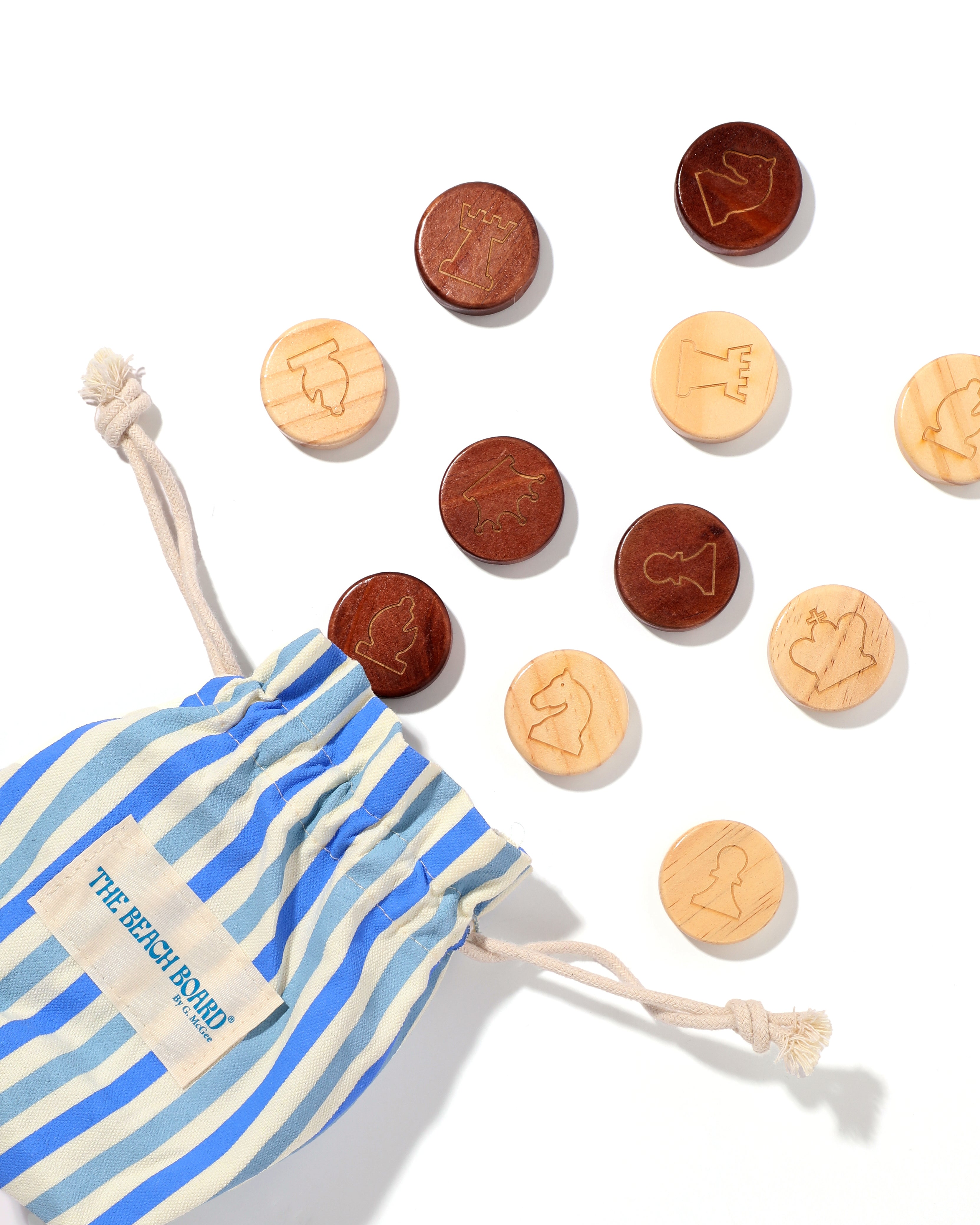 Wooden coins with animal designs on a white background, next to a striped drawstring bag.