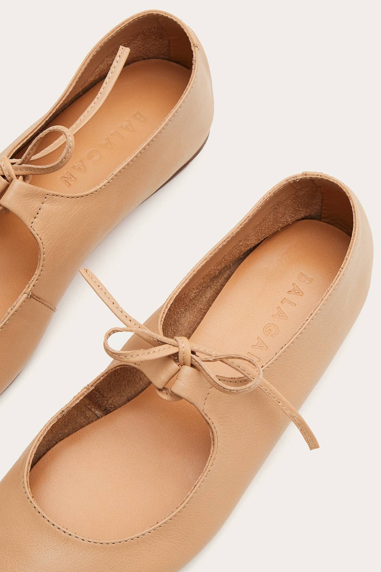 Pair of tan leather shoes with laces on a light background