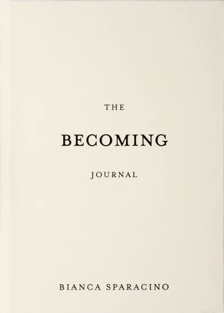 Book titled 'The Becoming Journal' by Bianca Sparacino on a wooden surface