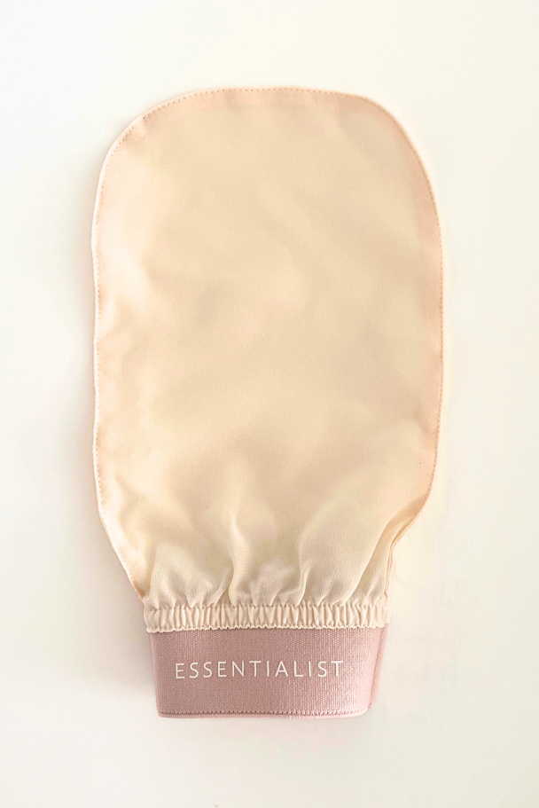 Beige rubber glove with 'Essentialist' branding on a light beige background