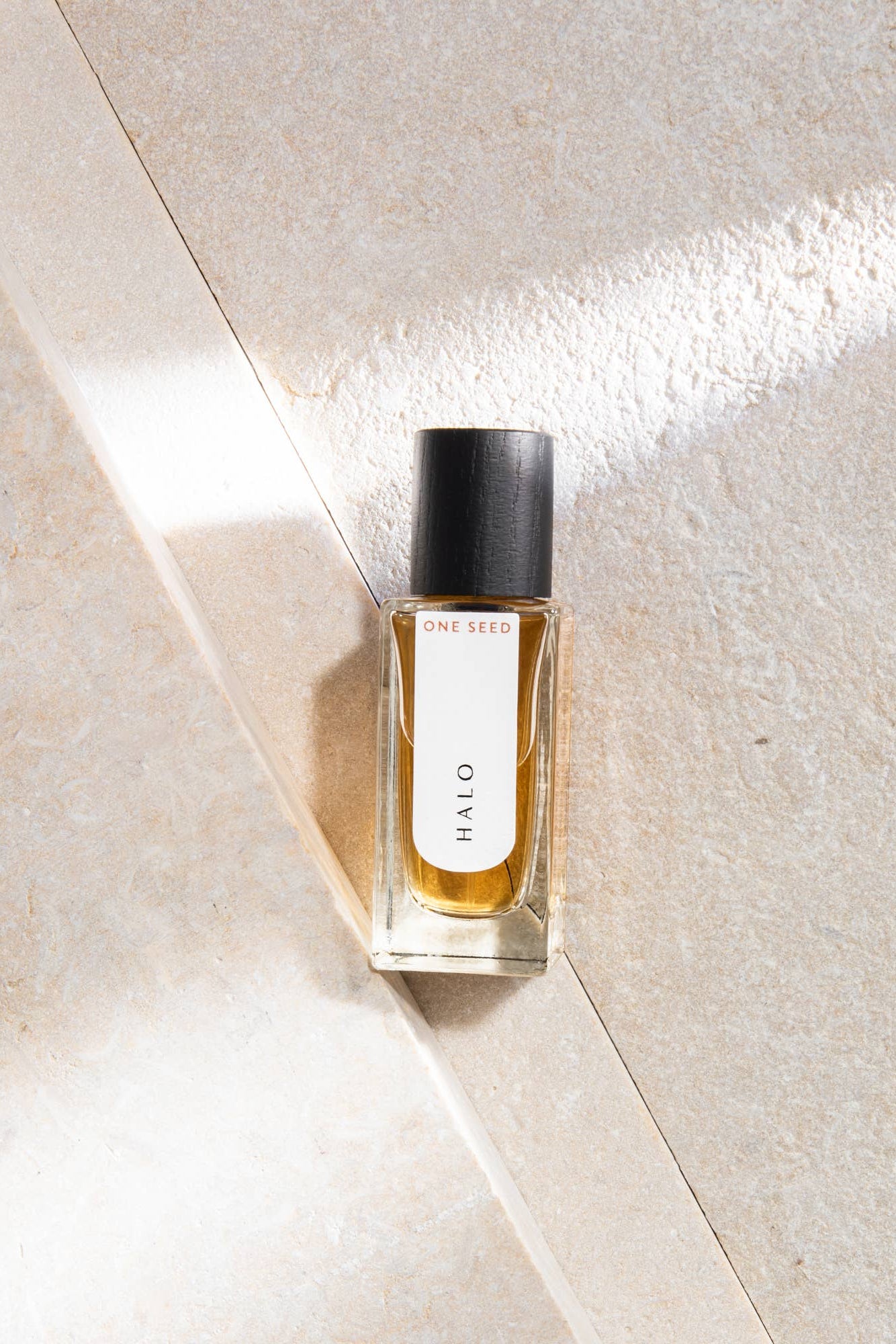 Perfume bottle labeled 'HALO' on a textured beige surface