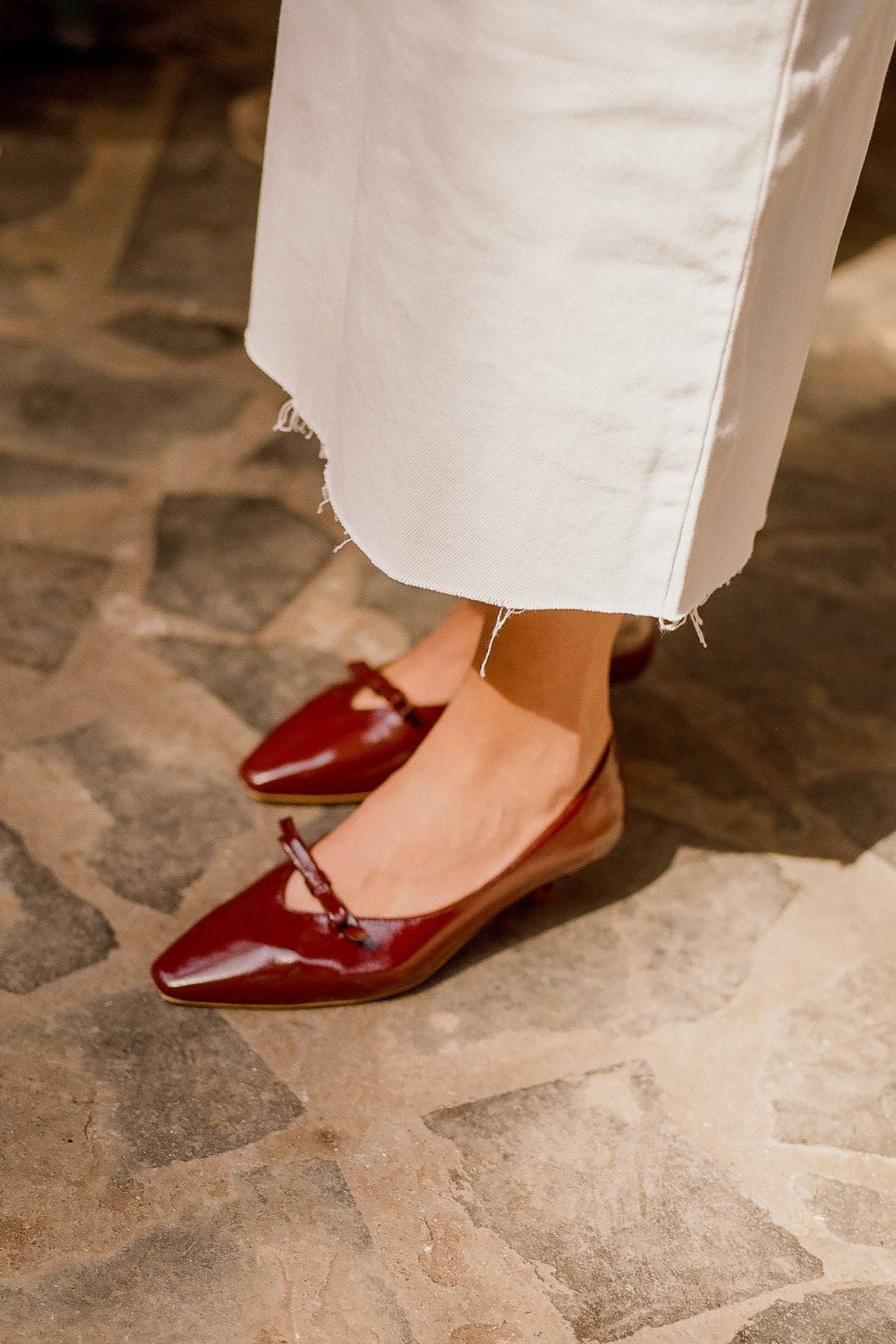 Red shoes worn on a stone pavement