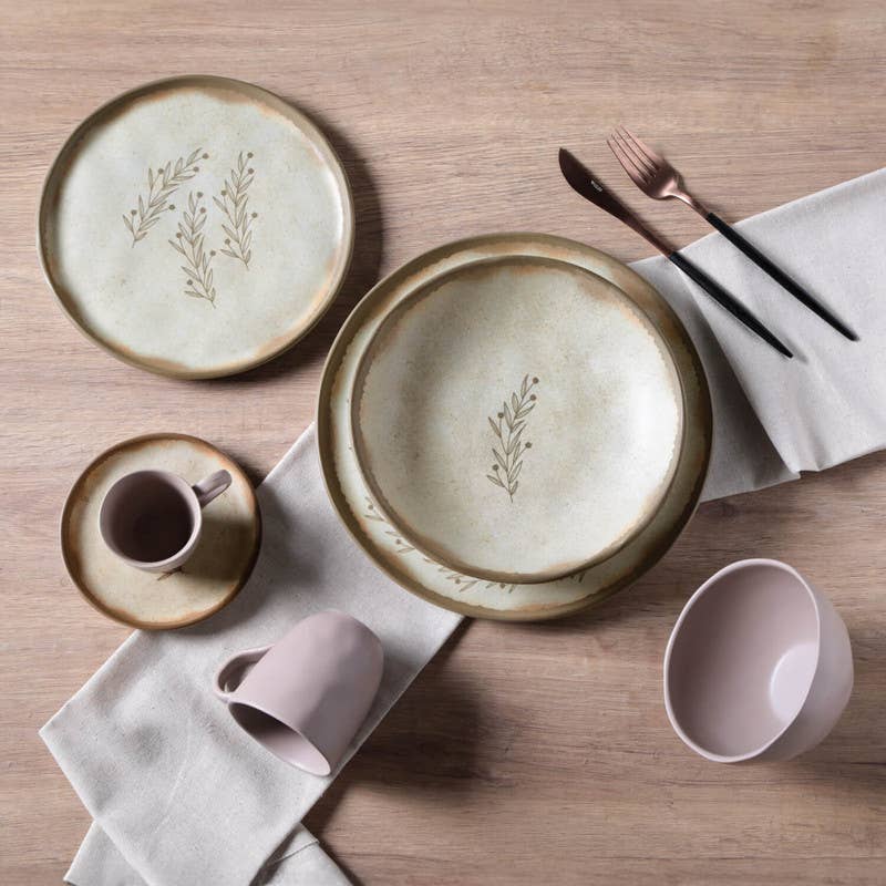 Ceramic tableware set with plates, cups, and cutlery on a wooden surface.