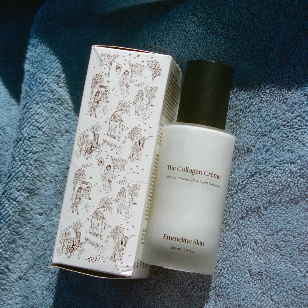Cosmetic bottle and packaging of 'The Collagen Crème' by Emmeline Skin on a blue towel.
