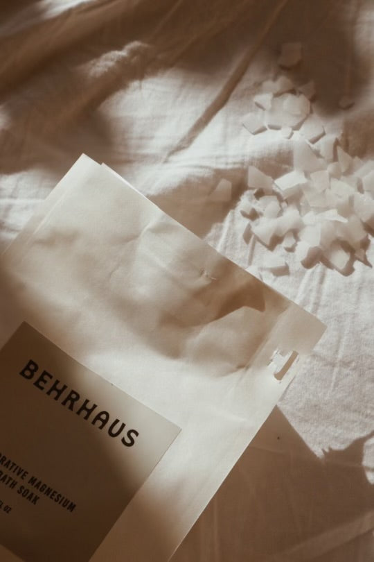 BEHRHAUS product packaging on a textured surface with light filtering through.