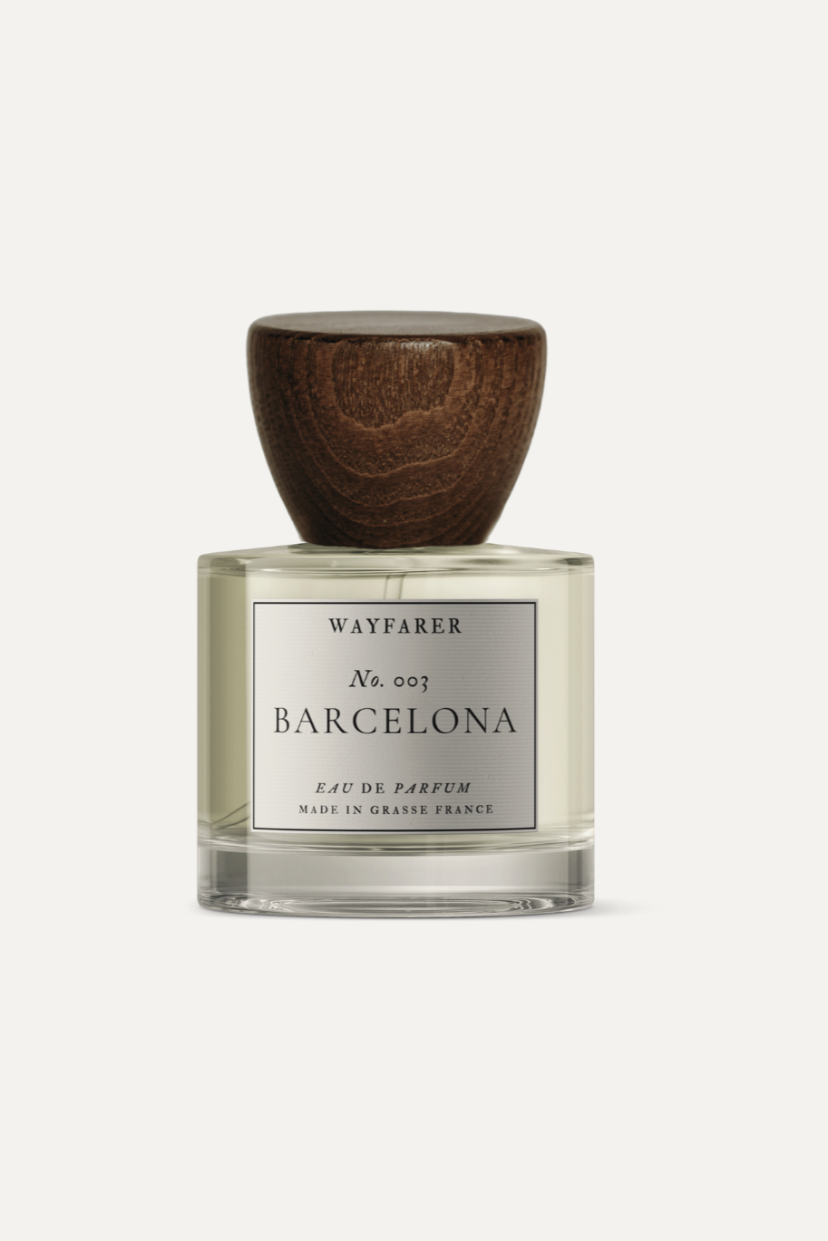 Perfume bottle labeled 'Wayfarer Barcelona' with wooden cap on a white background