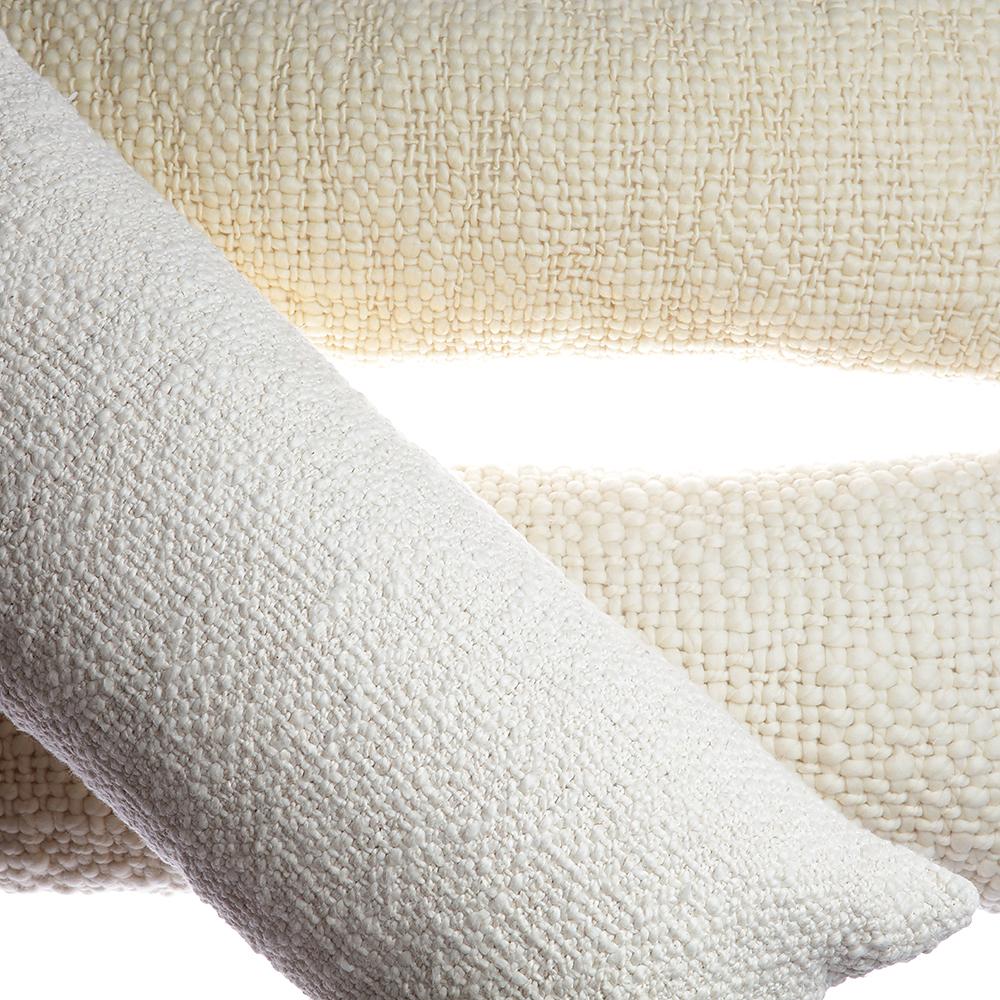 Close-up of textured white pillow on a neutral fabric background