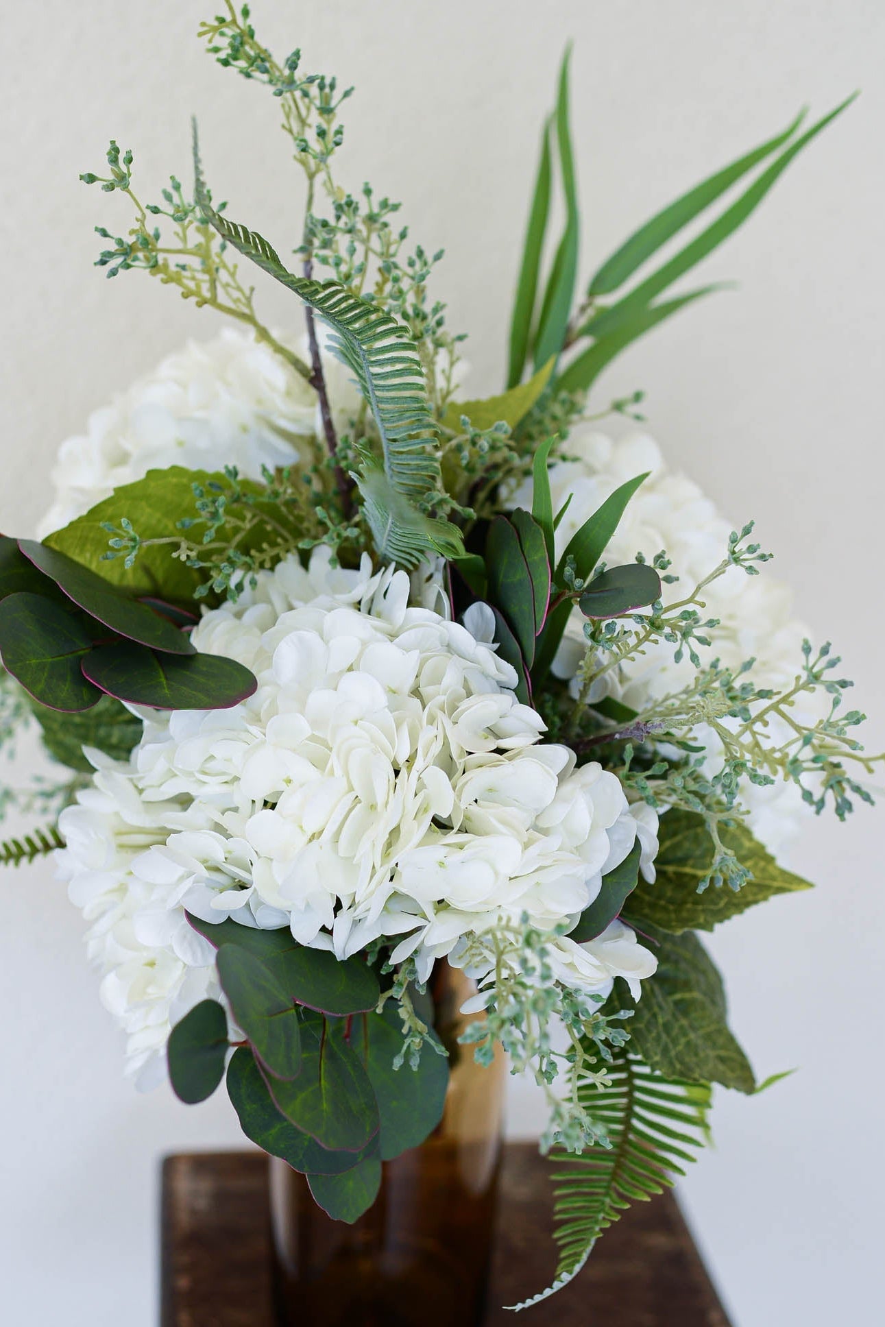 Bouquet of white flowers and greenery on a neutral background
