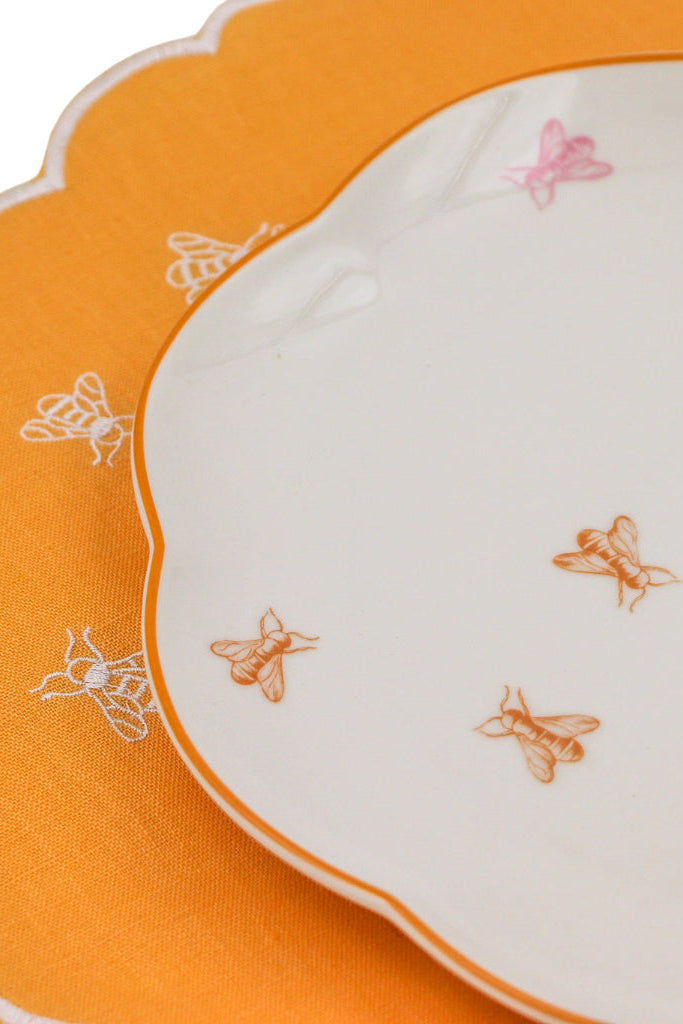 Orange and white fabric with embroidered bee patterns