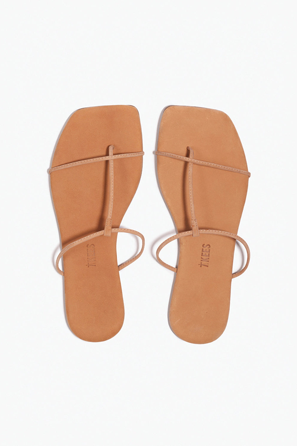 Pair of tan sandals with thin straps on a white background