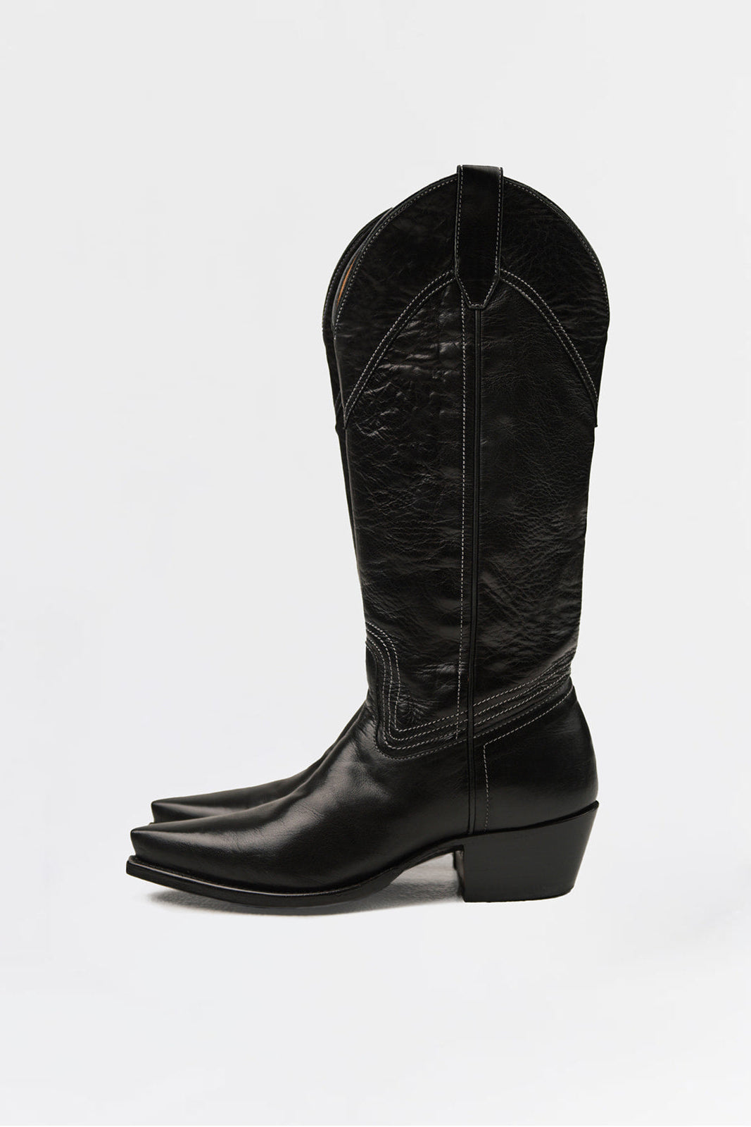 A single black leather cowboy boot with a pointed toe and low block heel, shown in profile against a plain white background.