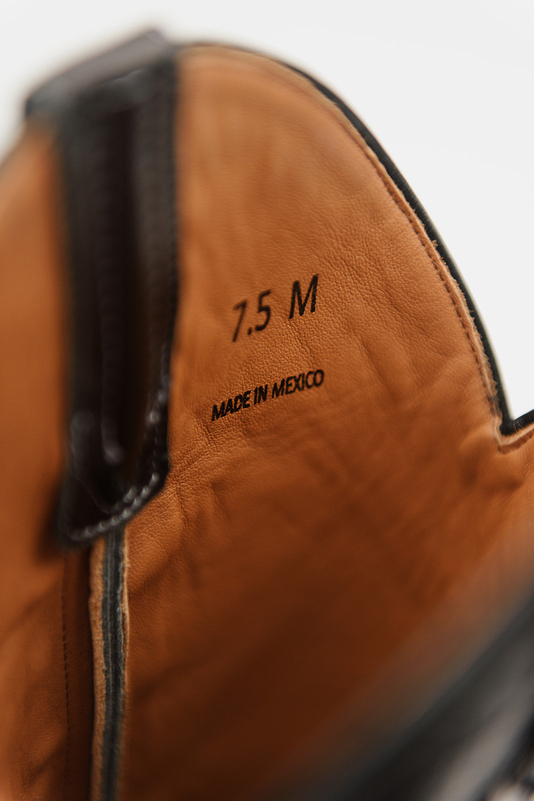 Close-up of the interior of a brown leather boot showing the size '7.5 M' and 'MADE IN MEXICO' printed on the insole.