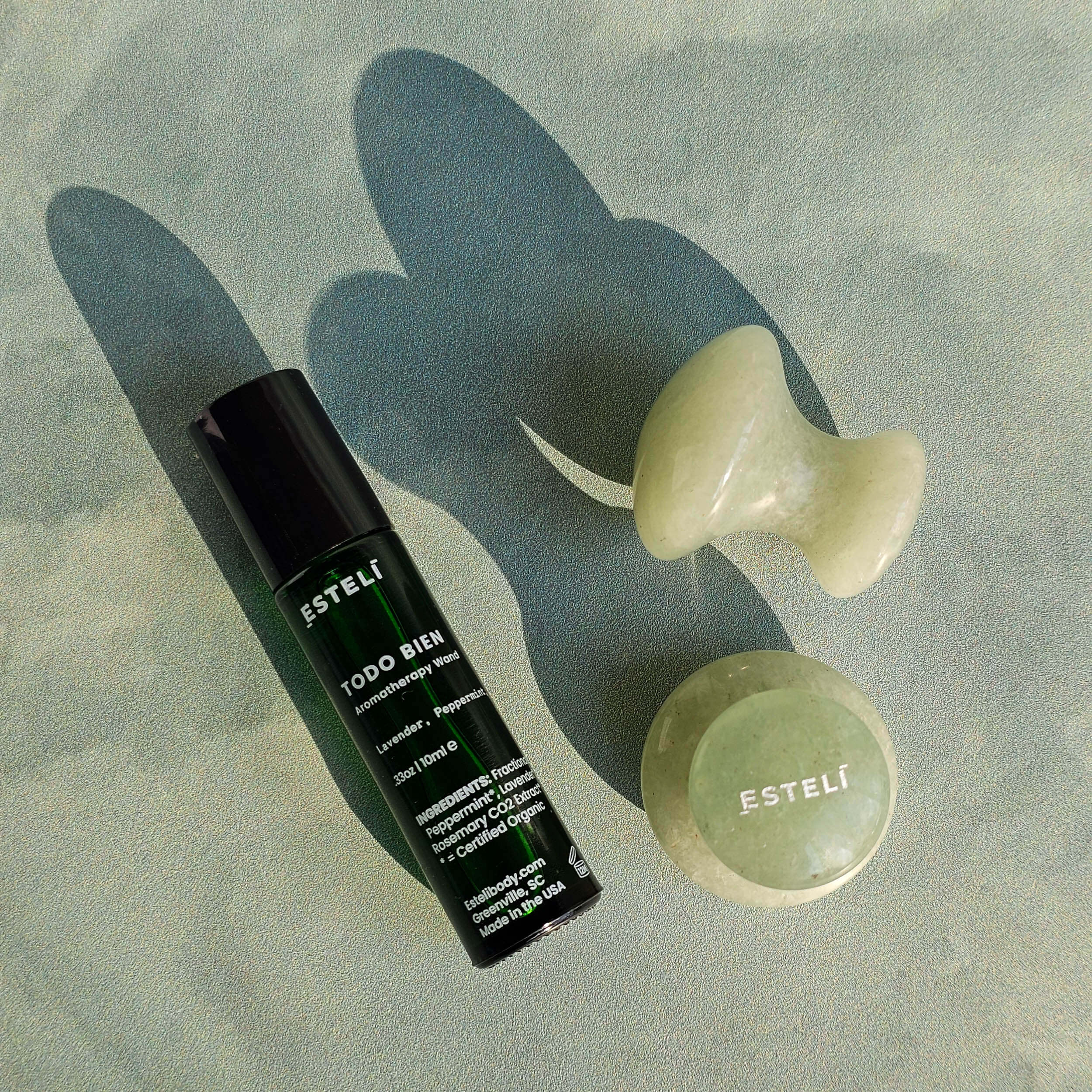 Esteli skincare products on a textured green background