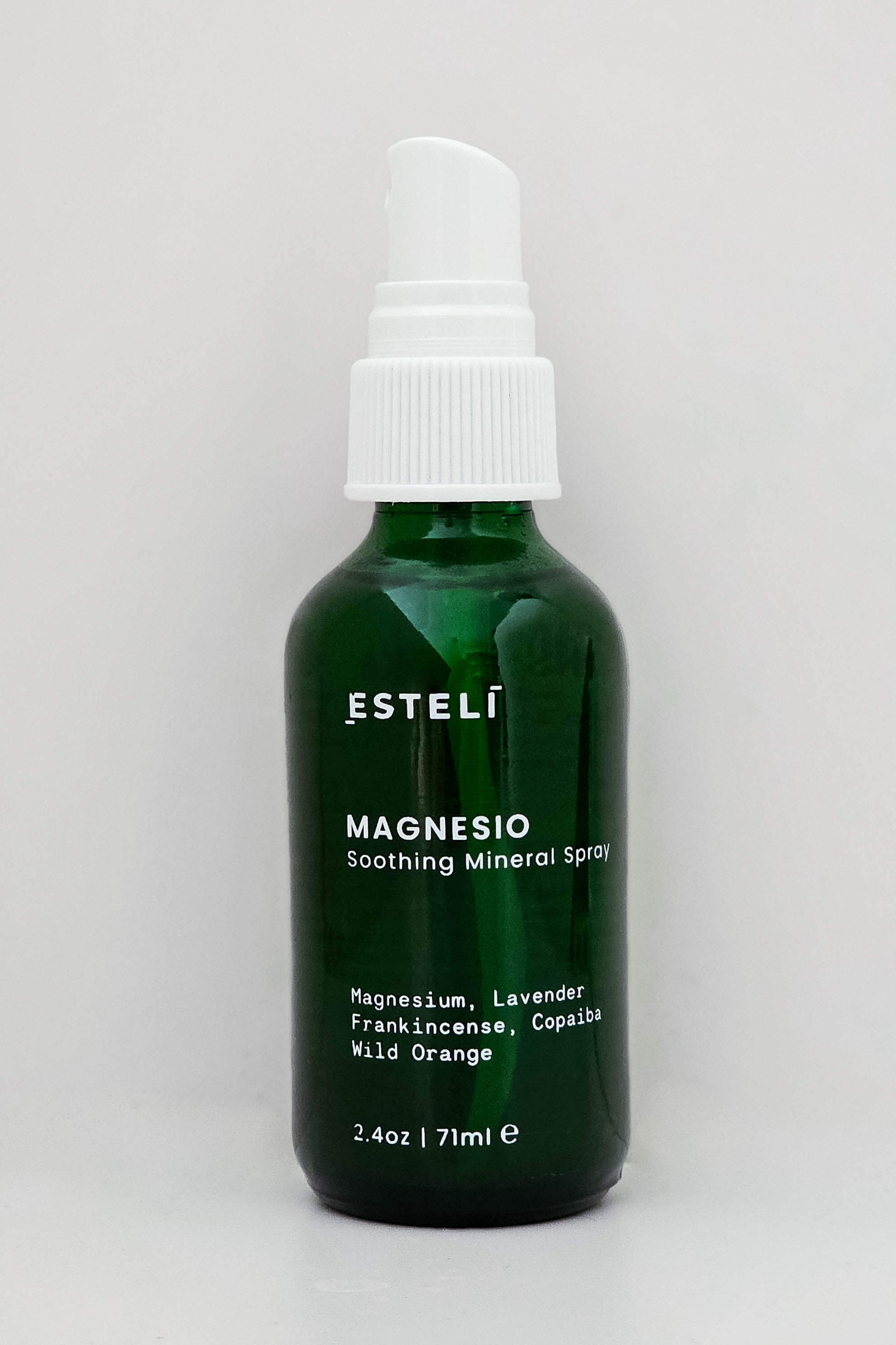 Green bottle of Estelí Magnesium Soothing Mineral Spray on a light gray background