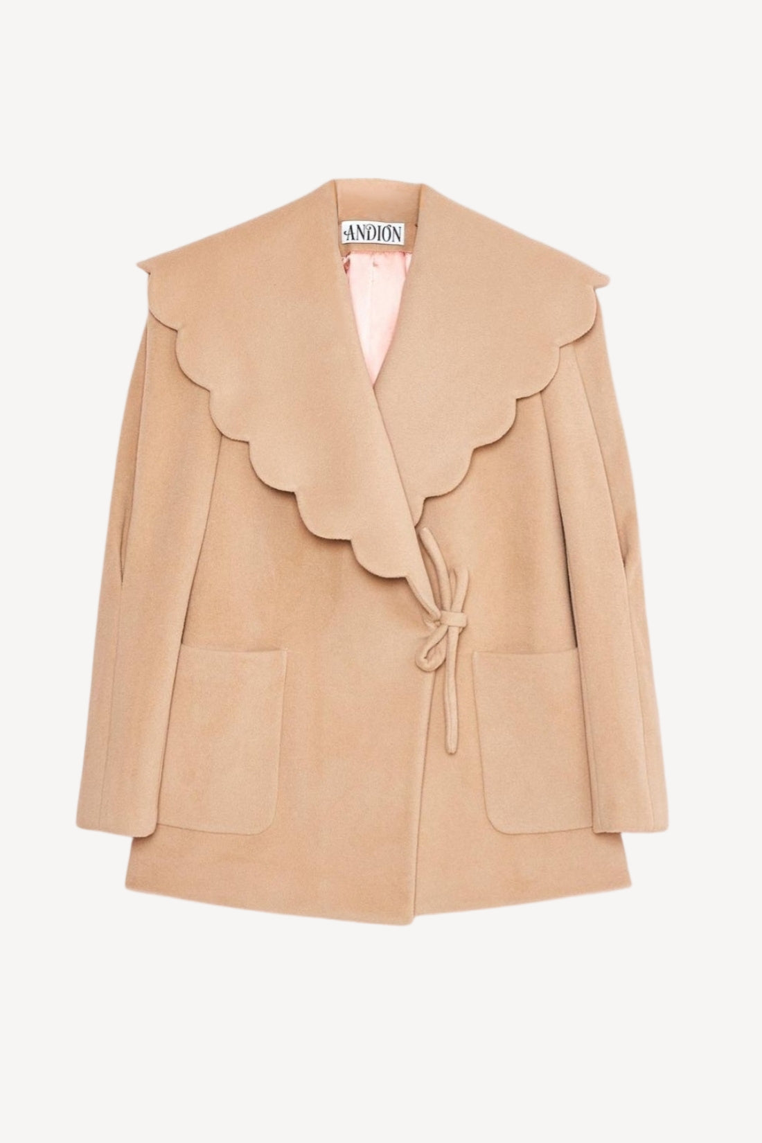 Beige jacket with scalloped edges on a white background
