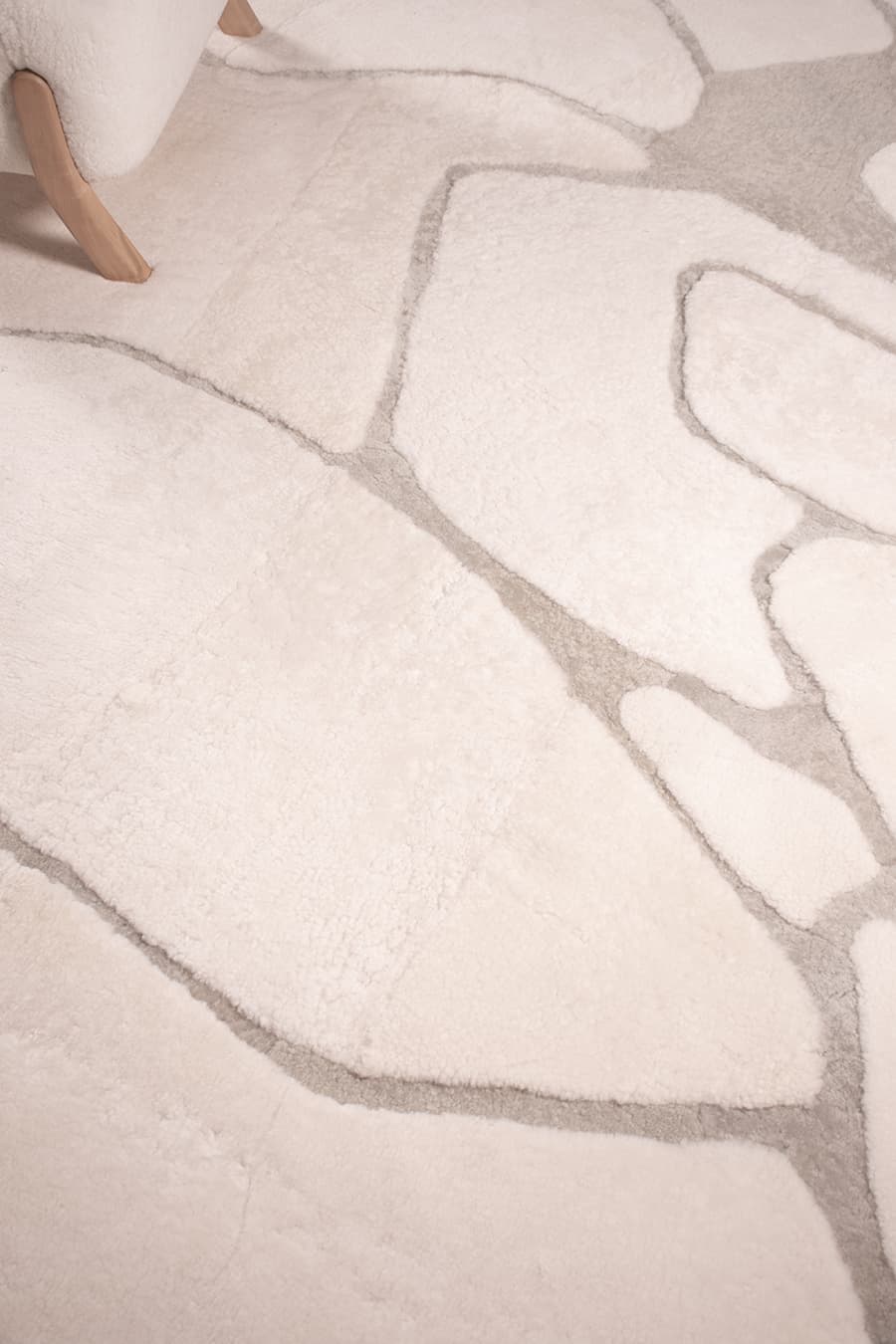 Close-up of a textured white and gray area rug with abstract pattern