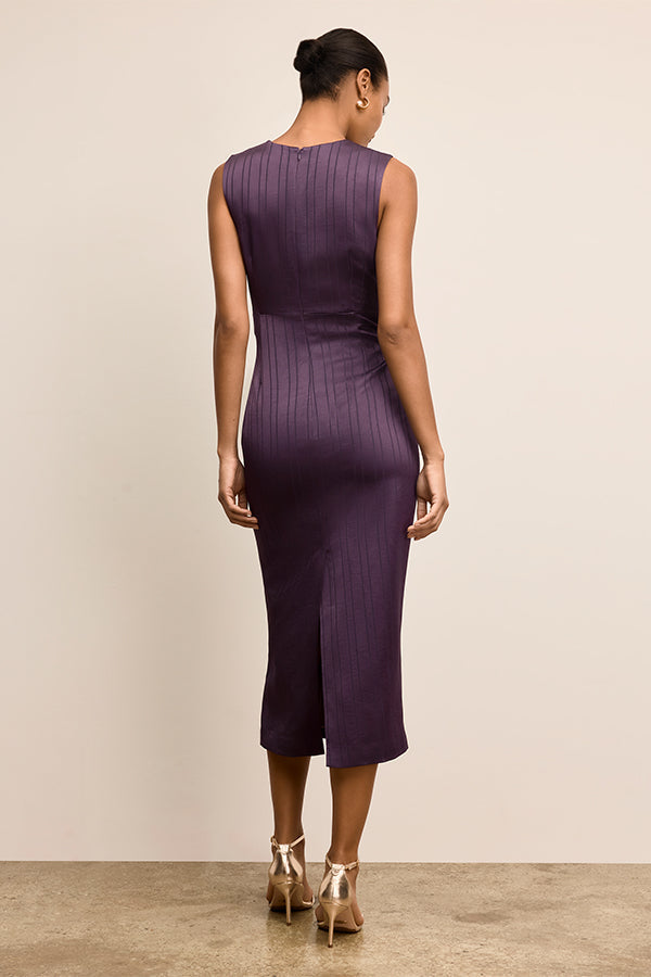 Woman wearing a purple dress against a beige background | Exclude