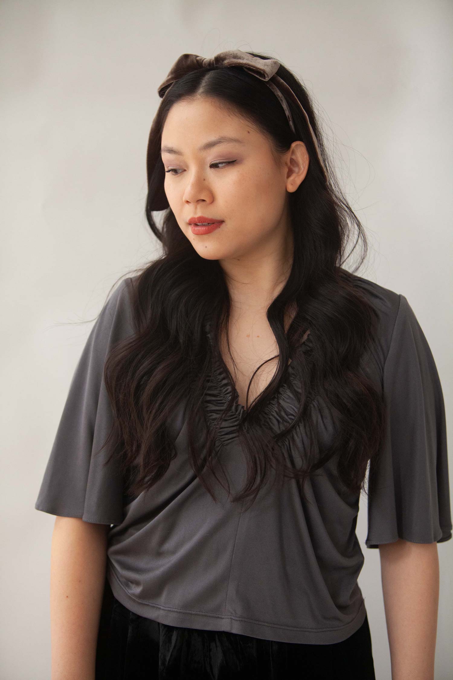 Woman wearing a luxurious brown silk velvet headband with bow