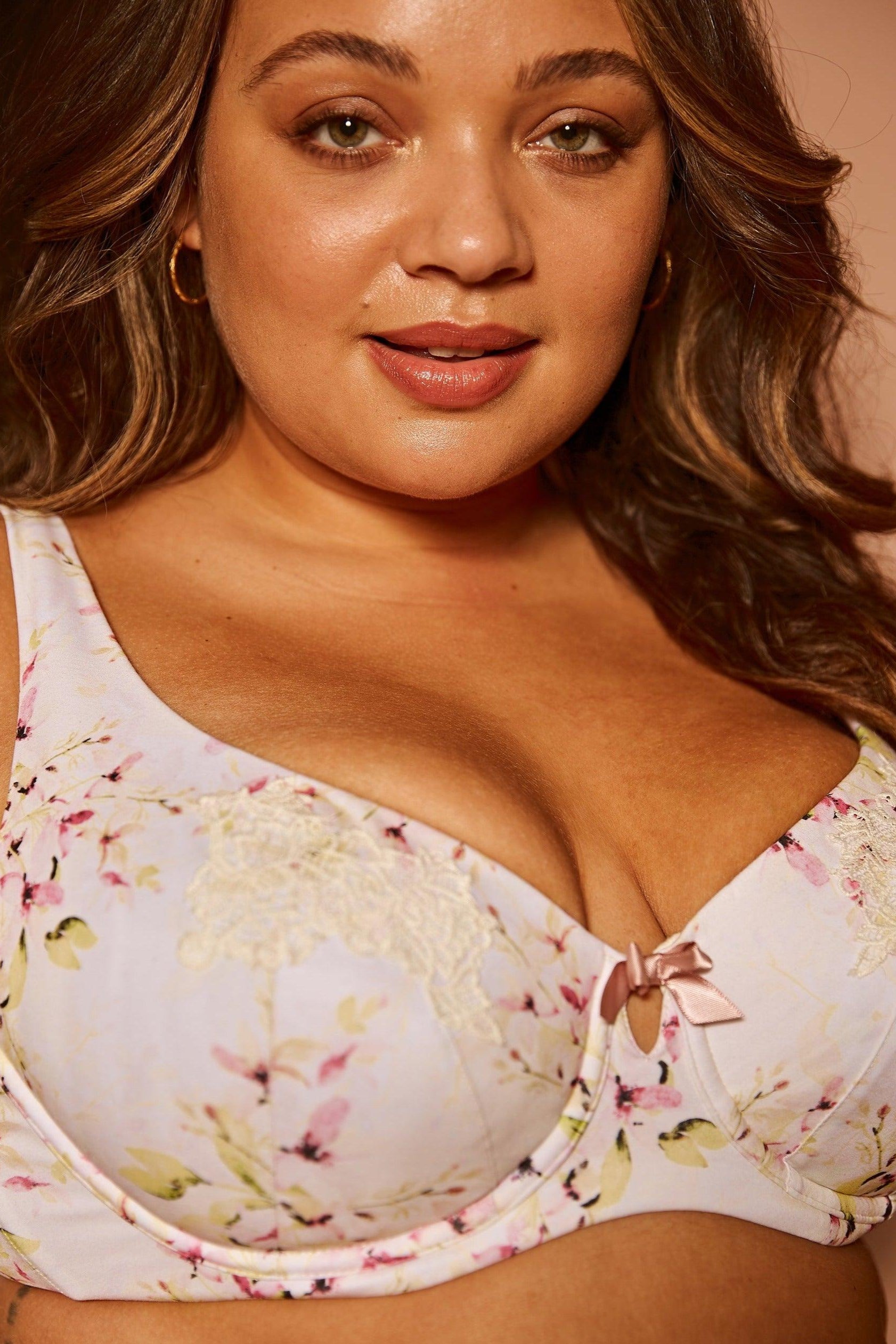 Woman wearing a floral bralette against a neutral background