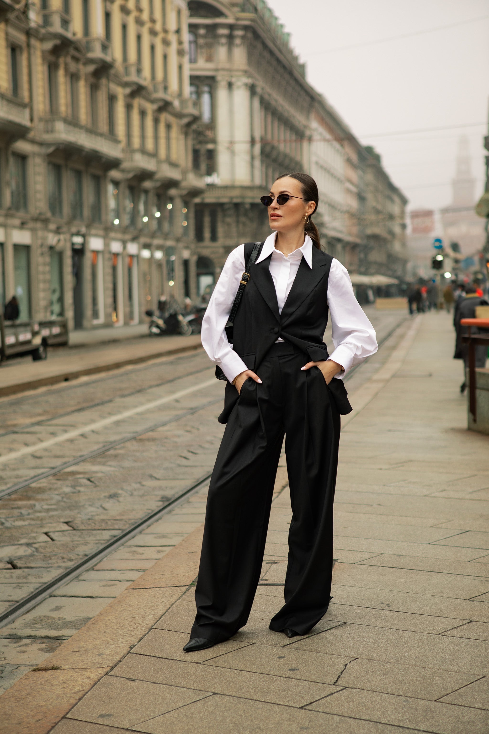 Woman in a formal outfit standing on a city street