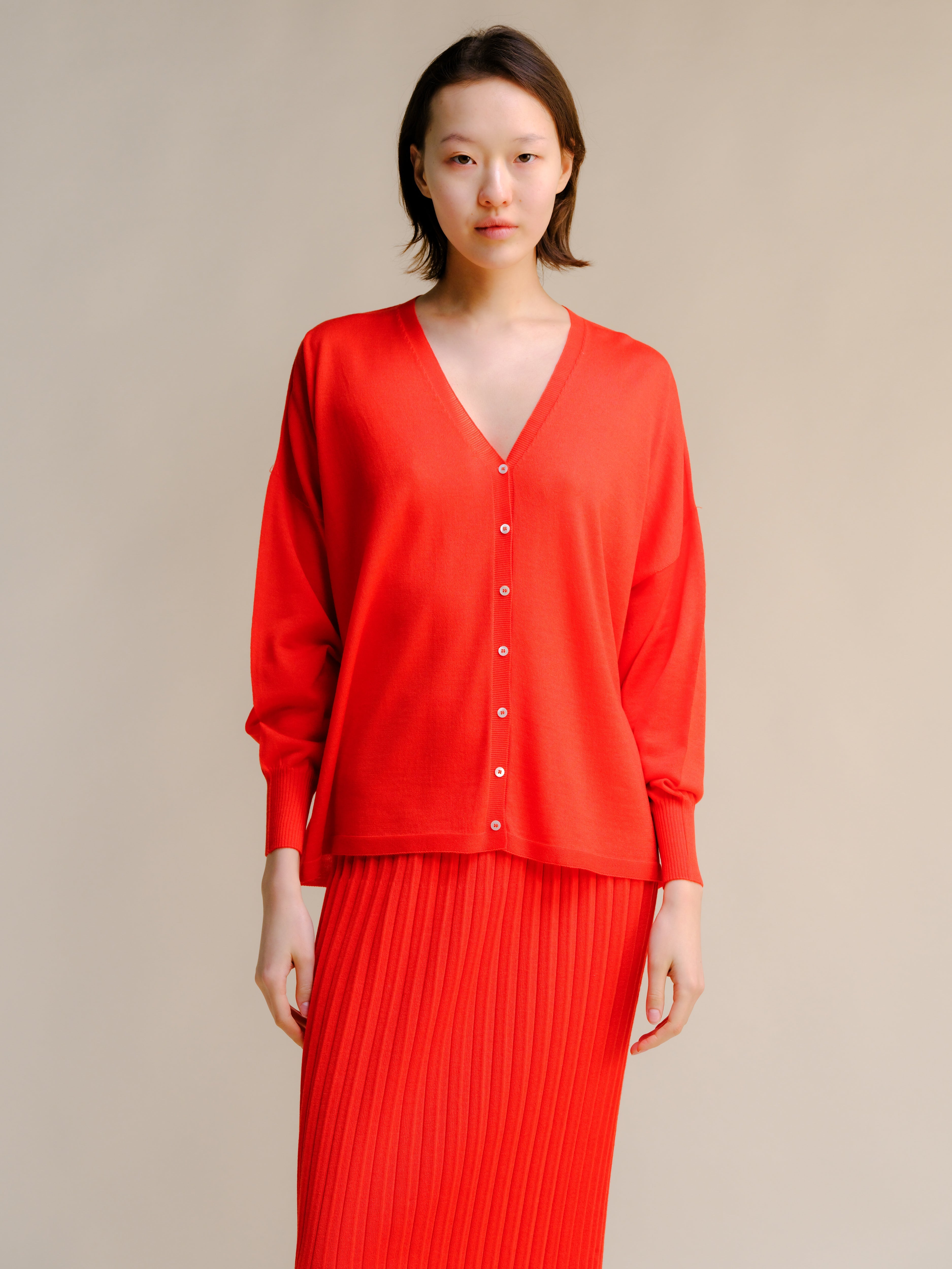 Woman wearing a red outfit with a plain background