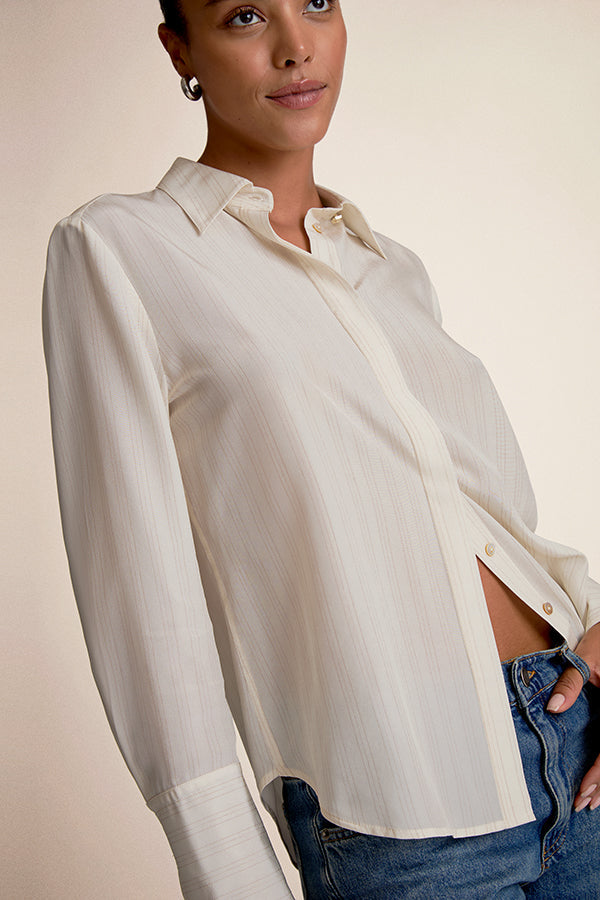 Woman wearing a white blouse and blue jeans against a beige background | Exclude
