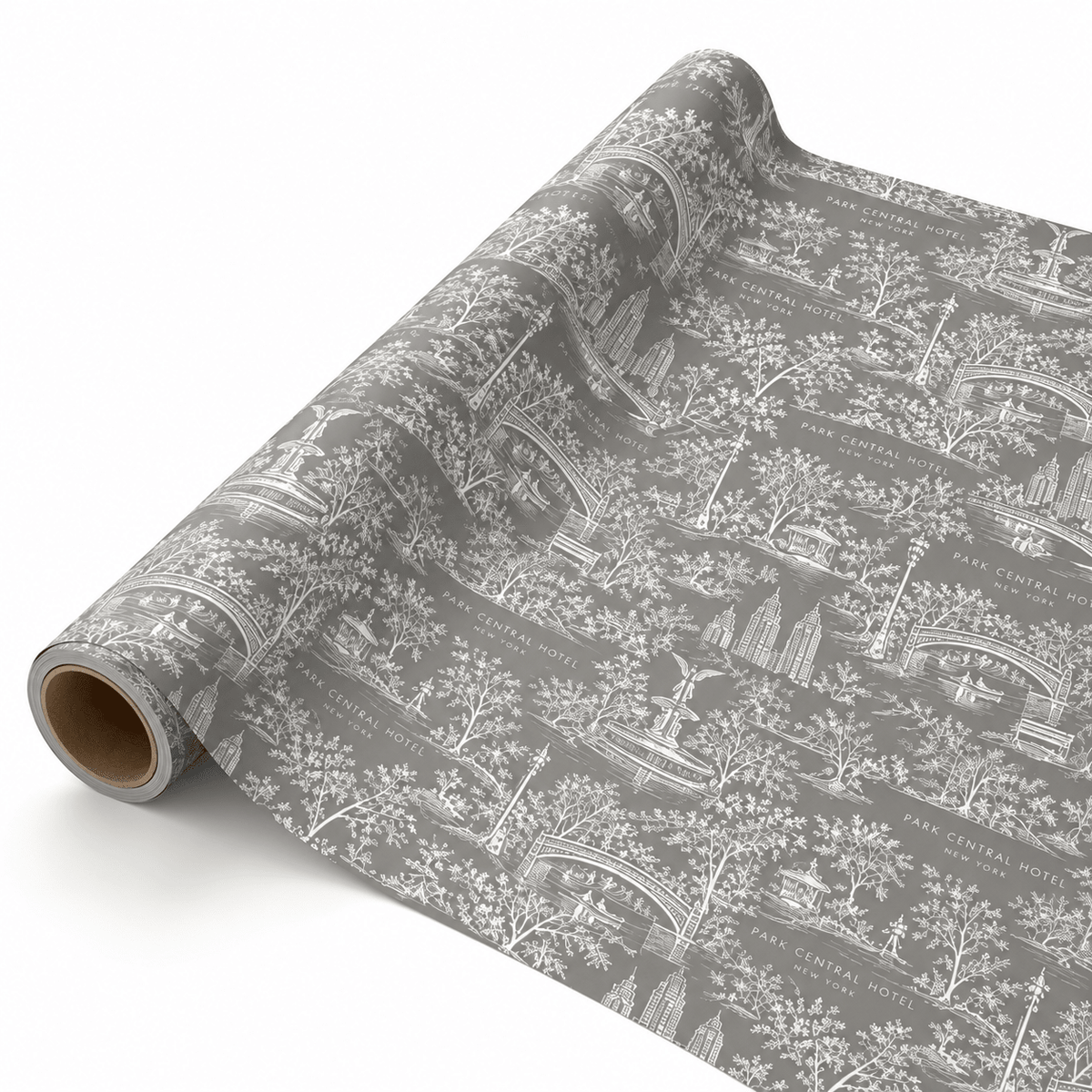 A roll of gray wrapping paper with a white toile de Jouy pattern, partially unrolled to show the design and texture on a clean white background.