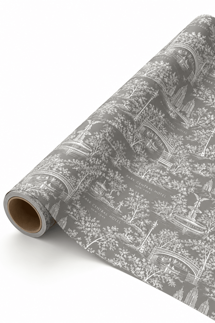 A roll of gray wrapping paper with a white toile de Jouy pattern, partially unrolled to show the design and texture on a clean white background.