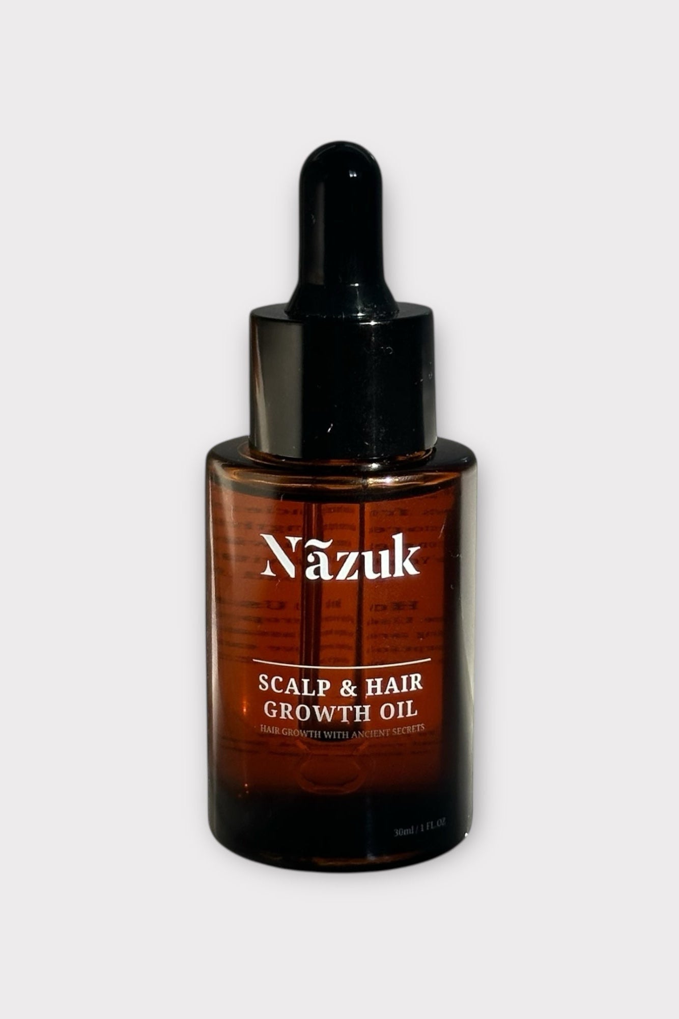 Bottle of Nazuk scalp and hair growth oil on a white background