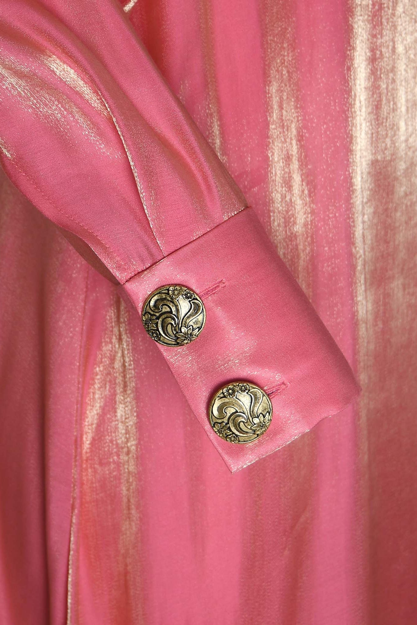 Close-up of a pink garment with decorative buttons on a white background