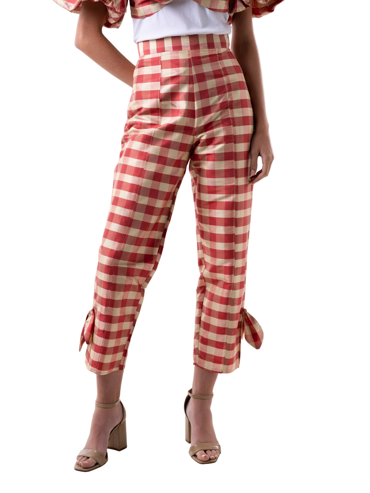 Person wearing red and white checkered pants on a white background