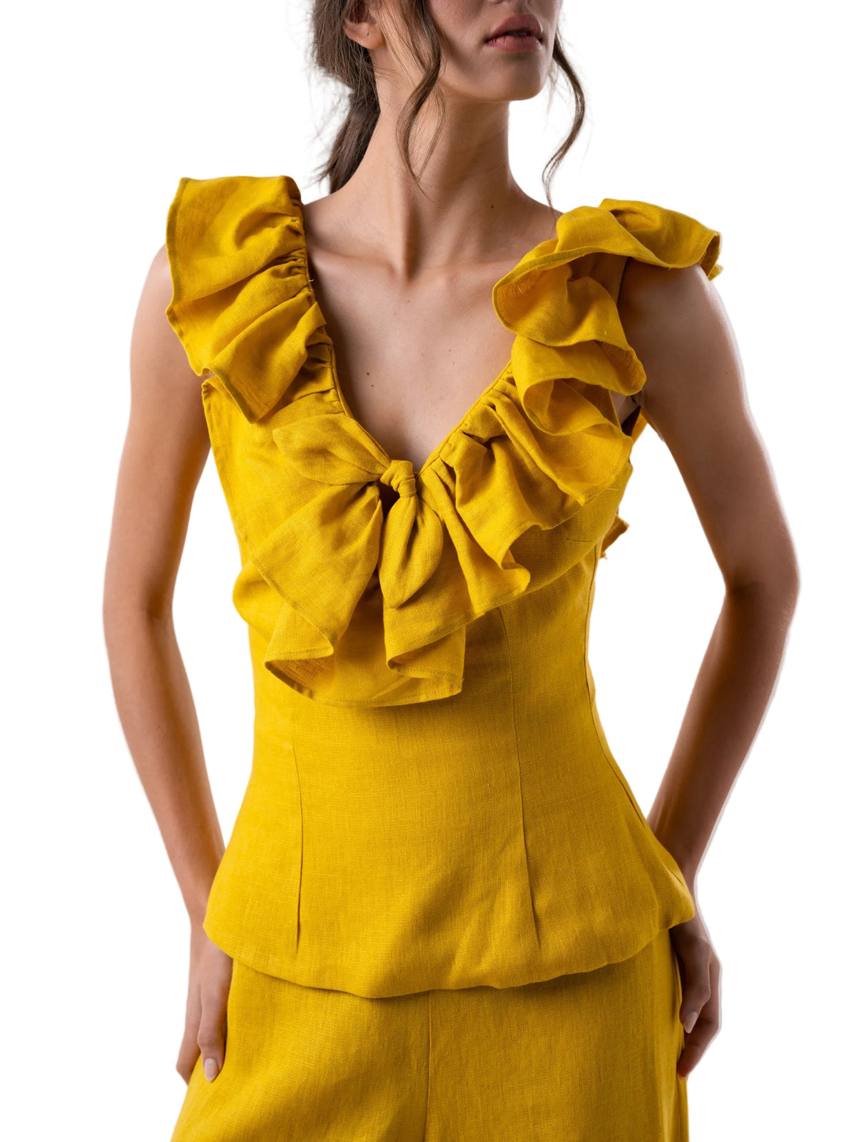 Yellow ruffled top worn by a model on a white background