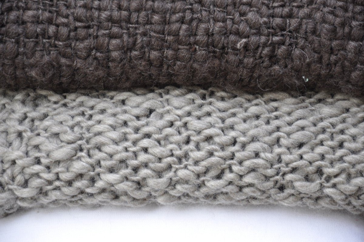 Close-up of two textured fabric swatches, one brown and one gray, on a white background.