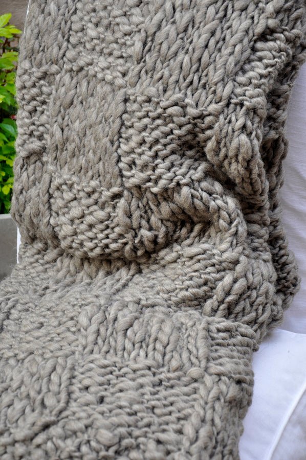 Close-up of a textured beige scarf with a white background