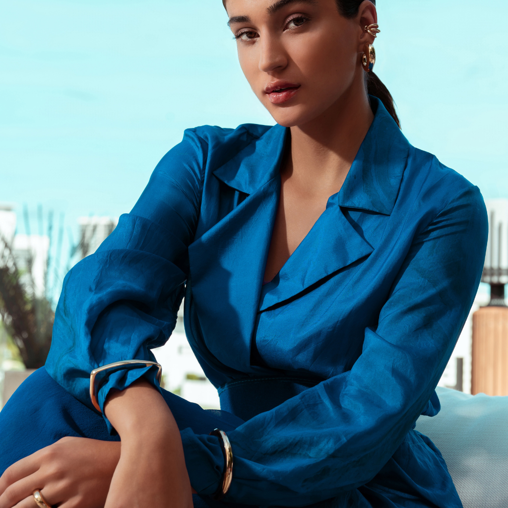 Woman wearing a blue outfit with a blurred outdoor background