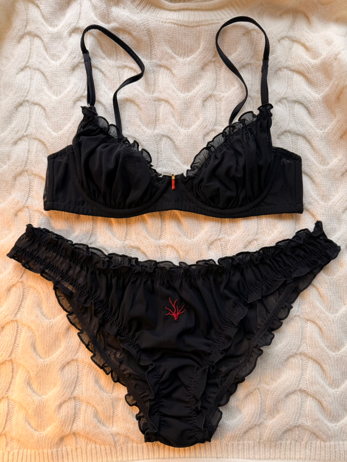 Black lingerie set on a textured beige surface