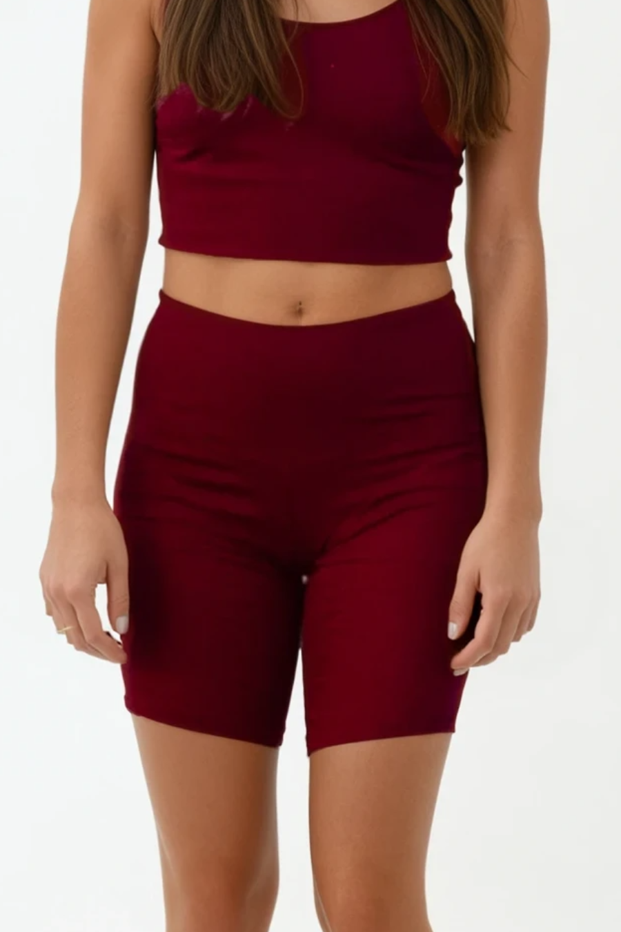 Person wearing a burgundy athletic outfit on a white background