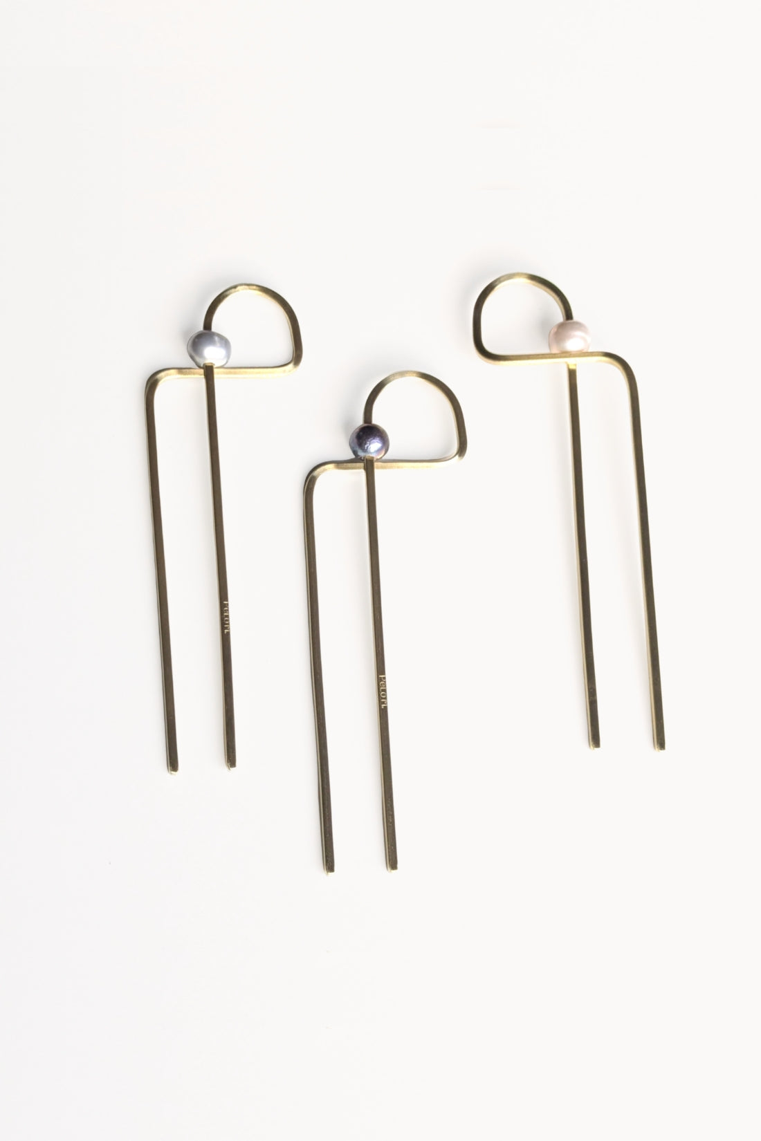 Three abstract gold hairpins with a central pearl, each a different color pearl