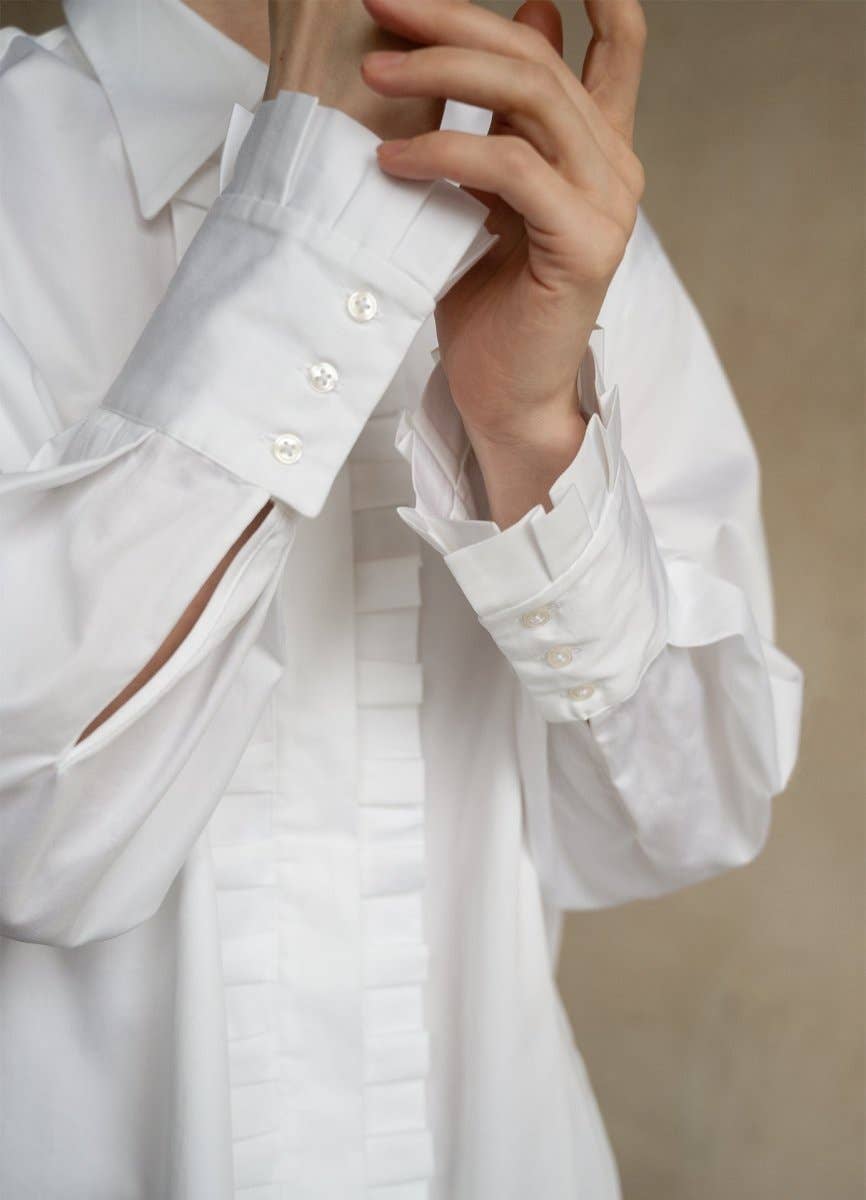 Close-up of a white shirt with ruffled sleeves on a neutral background