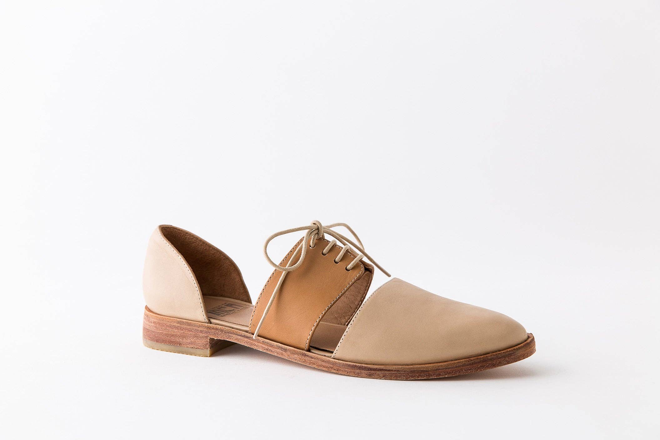 Two-tone shoe with tan and beige color scheme on a white background