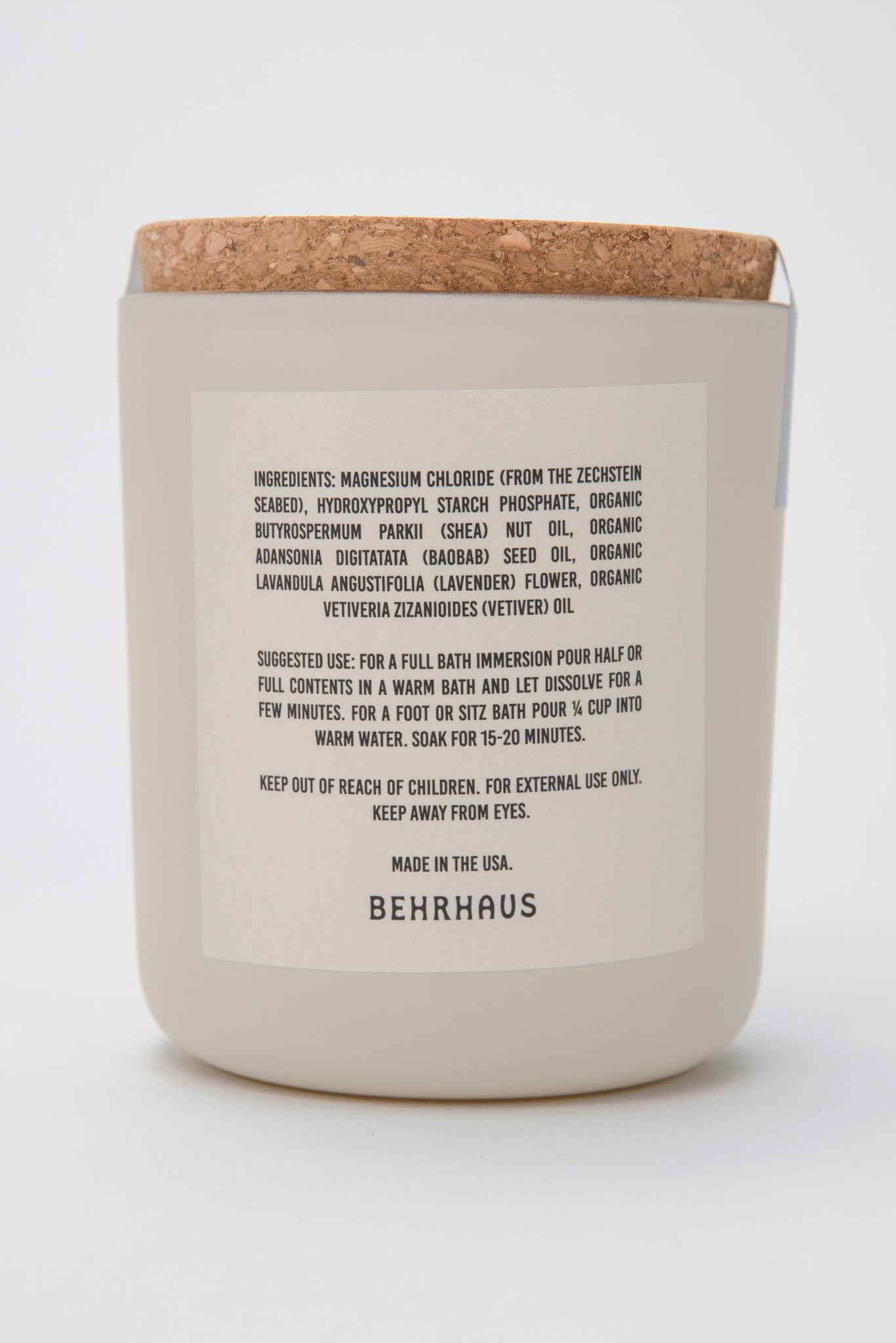 Ceramic candle with cork lid and label on a white background
