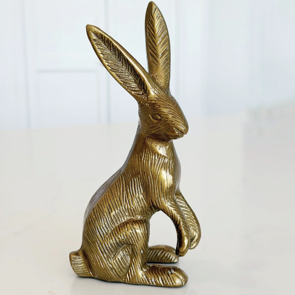 Bronze rabbit sculpture on a white background