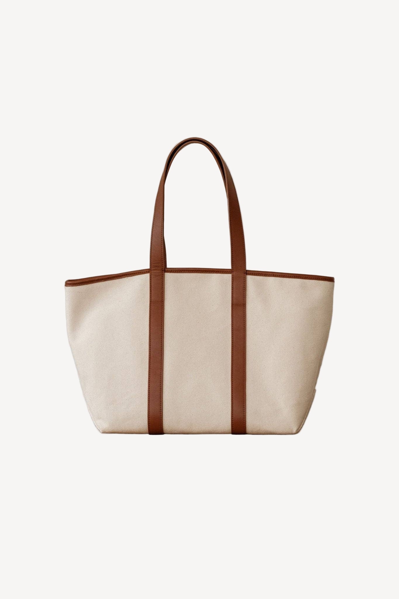 Beige tote bag with brown leather straps on a light gray background