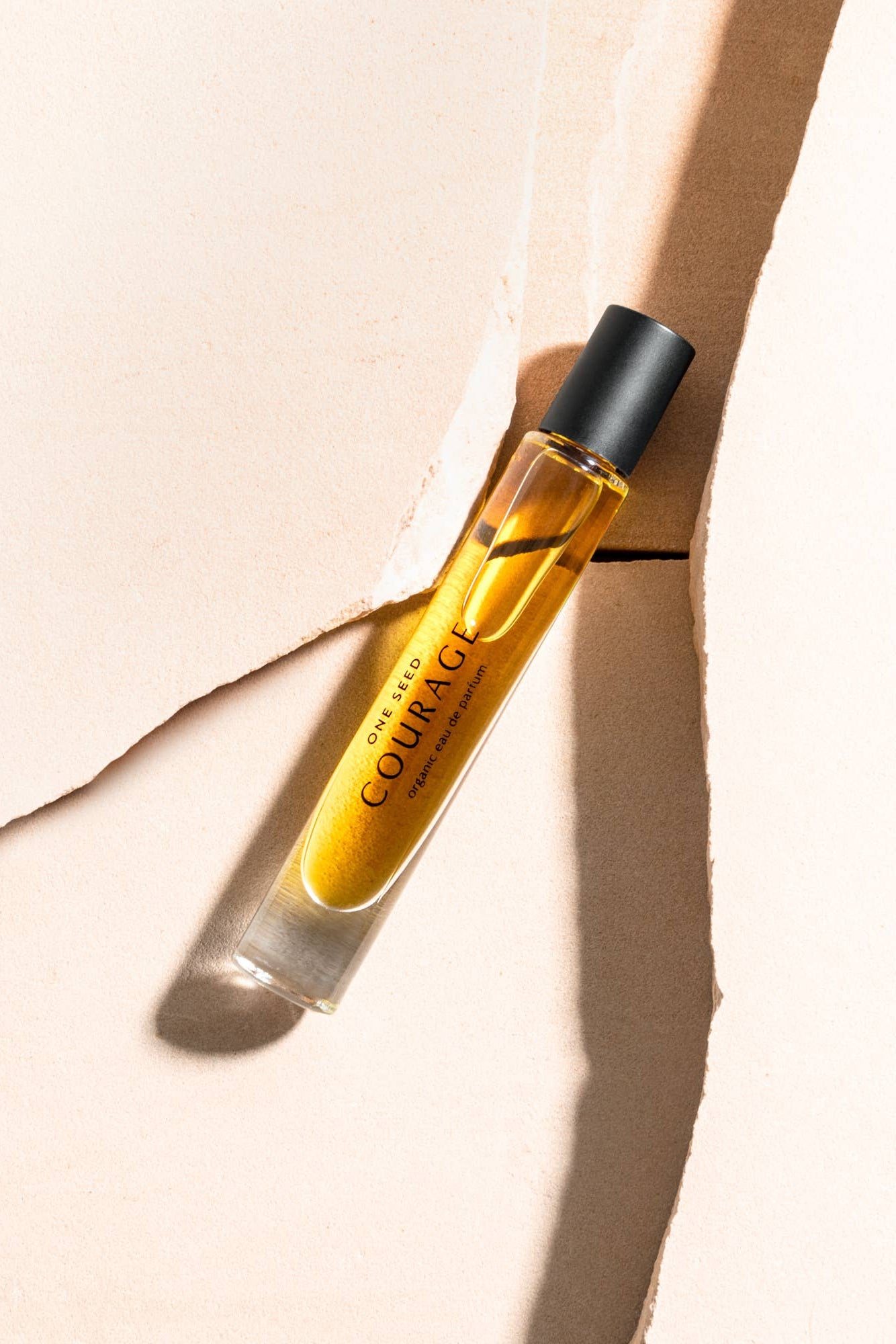 Perfume bottle labeled 'Courage' on a beige background